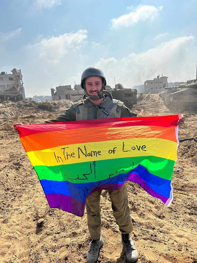 Yoav Atzmoni mengibarkan bendera LGBTQ+ di atas tanah Gaza sebagai respons saat melihat rumah-rumah Palestina dengan tulisan 