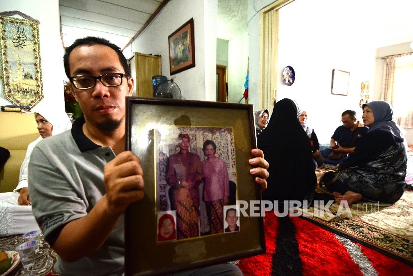 Yogi (41) memperlihatkan foto mertuanya, Masduki Mangkudisastra (75) yang menjadi korban terbakarnya KM Zahro Ekspress di rumah duka, Jalan Gambir Anom, Kel. Sukaluyu, Kec. Cibeunying Kaler, Kota Bandung, Senin (2/1).