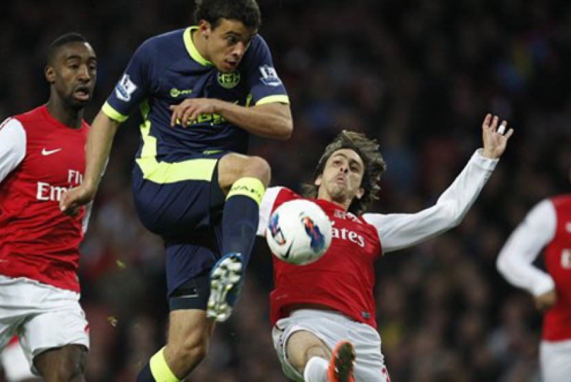  Yossi Benayoun, kanan, berusaha menghalau pemain Wigan Franco Di Santo menendang. Tendangan tersebut berbuah gol. Pertandingan berlangsung di Stadion Emirates London, Selasa (17/4) WIB.  