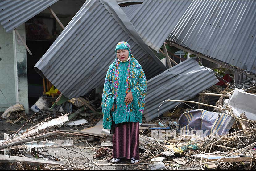 Yuslifa berpose di depan rumahnya yang rusak akibat likuifkasi di Lere, Palu, Sulawesi Tengah.