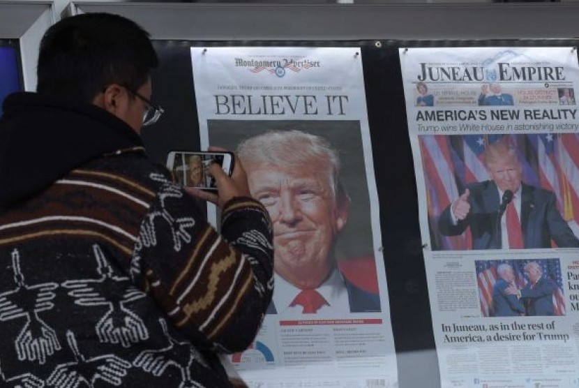  Zheng Gao dari Shanghi, Cina memotret halaman depan beberapa harian yang dijual di Washington, sehari setelah kemenangan Presiden AS Donald Trump.  