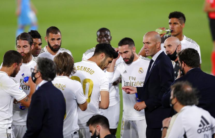 Zinedine Zidane berbicara kepada para pemainnya saat jeda paruh pertama laga Madrid kontra Valencia, Jumat (19/6)