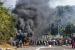 Penjarah di luar pusat perbelanjaan di sepanjang barikade yang terbakar di Durban, Afrika Selatan