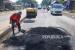 Pekerja menguruk jalan yang rusak akibat banjir dengan pasir saat perbaikan di jalan pantura, Karanganyar, Demak. Kapolri siapkan jalur alternatif dari 116 titik rawan banjir di jalur mudik tahun ini