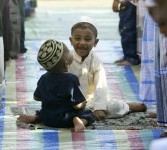 Anak Muslim Sri Lanka bermain ketika orang tua mereka sholat Idul Fitri di Kolombo, Sri Lanka.