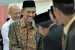 Direktur Jendral Haji dan Umroh Anggito Abimanyu memberikan ucapan selamat usai acara pengukuhan panitia penyelenggara ibadah haji (PPIH) embarkasi Jakarta Pondok Gede, Selasa (20/8).  (Republika/Rakhmawaty La'lang)