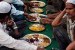 Jamaah Muslim berkumpul untuk berbuka bersama dengan piring-piring berisi bermacam makanan, di Allahabad, India.