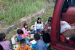 Pemudik lokal bersama keluarganya menyantap hidangan di bahu jalan di jalur mudik selatan, Rabu (5/6) sore. 