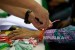  Petugas kesehatan memasang gelang kepada jamaah calon haji Kloter 25 di Embarkasi DKI Jakarta, Pondok Gede, Jakarta, Selasa (8/8)