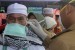  Petugas kesehatan memeriksa suhu tubuh seorang haji dengan alat pengukur saat kedatangan jamaah haji di Asrama Haji Provinsi Bengkulu. (Ilustrasi)