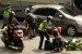  Petugas Polisi menolong pengendara motor yang terjatuh di Jalan Cagak Nagreg, Kabupaten Bandung, Ahad(27/7). (foto : Septianjar Muharam)