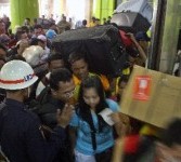 Ratusan calon penumpang kereta api mengantre saat memasuki Stasiun Gambir di Jakarta, Jumat (26/8).