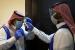 Kemenkes Saudi Layani 216.981 Jamaah Haji. Foto:   Relawan Arab Saudi memeriksa suhu tubuh rekannya menyusul pandemi virus Covid-19 di Riyadh, Arab Saudi.