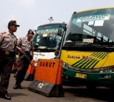 Sejumlah petugas kepolisian dan Pasukan Brimob Polda Metro Jaya melintas depan bus antar kota antar provinsi saat pengamanan terminal di terminal Kampung Rambutan, Jakarta Timur, Selasa (23/8). 