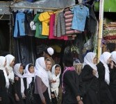 Sejumlah siswi bergegas menuju sekolah. Mereka melewati kios pedagang baju bekas.