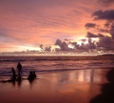 Sejumlah wisatawan bermain air saat matahari terbenam di pantai Palabuhanratu, Sukabumi, Jawa Barat. 