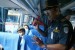 Seorang petugas dari tim gabungan Kepolisian dan Dishub memberitahukan cara penggunaan palu pemecah kaca kepada sejumlah penumpang dan awak bus saat razia angkutan mudik Lebaran di Terminal Arjosari, Malang, Jatim