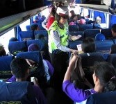Seorang polwan anggota Sat Lantas Polrestabes Surabaya, membagikan brosur Sosialisasi Mudik Aman kepada penumpang bus di Terminal Purabaya Bungurasih Surabaya, Jatim, Jumat (26/8). 