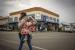 Oman, UEA, dan Mesir Blokir Penerbangan dari Afrika Selatan. Seorang wanita bertopeng menggendong seorang anak berjalan melalui jalan-jalan di kota pedesaan Parys, Afrika Selatan, 26 November 2021. Departemen Kesehatan Afrika Selatan dan ilmuwan dari Network for Genomic Surveillance mengungkapkan rincian Covid-19 yang baru terdeteksi dan sangat bermutasi varian, B.1.1.529.