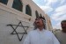 Seorang warga Palestina berdiri di depan masjid yang menjadi korban vandalisme Yahudi, di Nablus, Tepi Barat.