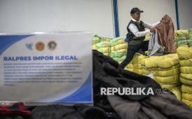 Petugas menunjukkan barang bukti pakaian bekas saat ekspose hasil pengawasan barang impor tidak sesuai ketentuan di Bojongsoang, Kabupaten Bandung, Jawa Barat, Selasa (19/8/2025). 