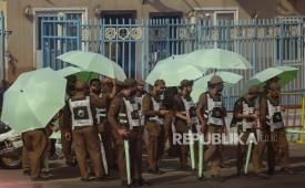 Polisi lalu lintas Saudi mengangkat payung di kamp tenda Mina, di kota suci Mekah, Arab Saudi, Selasa, 5 Juli 2022. Arab Saudi diperkirakan akan menerima satu juta Muslim untuk menghadiri ibadah haji, yang akan dimulai pada 7 Juli, setelah dua tahun membatasi jumlah karena pandemi coronavirus.