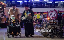 Petugas mendorong kursi roda seorang calon haji lansia menuju ruang aula di Grand El-Hajj Asrama Haji Banten, Kota Tangerang, Banten, Selasa (21/4/2026). Asrama haji tersebut mulai beroperasi perdana tahun ini dengan melayani sebanyak 9.192 calon haji asal Provinsi Banten yang terbagi dalam 24 kelompok terbang (kloter) mulai 21 April hingga 18 Mei 2026. 