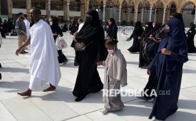 Seorang anak bersama orangtuanya melakukan tawaf. Jamaah calon haji diimbau mengurangi aktivitas yang tidak perlu.