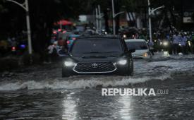 Pengendara menerobos genangan air di Jalan (ilustrasi). 