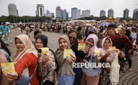 Warga menunjukkan kupon sembako saat antre pada Pasar Murah untuk Rakyat di kawasan Monas, Jakarta, Sabtu (28/3/2026). Pemerintah menyediakan 100.000 kupon belanja sembako dan barang gratis senilai Rp500.000 serta 300.000 porsi makanan gratis yang disajikan oleh sekitar 800 pedagang kaki lima untuk masyarakat pada acara tersebut. 