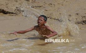 Anak-anak bermain di genangan air banjir bandang yang melanda di kawasan Desa Batu Bedulang, Aceh Tamiang, Aceh, Selasa (23/12/2025). Aktivitas tersebut dilakukan anak-anak untuk mengisi waktu di tengah situasi bencana banjir bandang di kampungnya. Meski demikian, sejumlah anak mengaku senang dengan aktivitas tersebut karena dilakukan secara bersama.