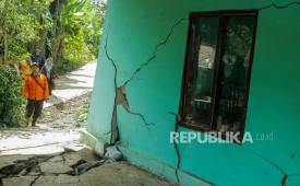 Petugas mengamati tembok rumah yang retak akibat pergerakan tanah di Jatisari, Bojongpicung, Kabupaten Cianjur, Jawa Barat, Sabtu (27/4/2024). Badan Penanggulangan Bencana Daerah (BPBD) Cianjur mencatat sebanyak 34 unit rumah warga rusak, dua fasilitas umum rusak, akses jalan desa retak dan sebanyak 77 Kepala Keluarga (KK) terpaksa mengungsi ke tempat yang aman akibat musibah pergerakan tanah tersebut. 
