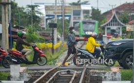 Relawan mengatur arus lalu-lintas di perlintasan kereta api (KA) sebidang tanpa palang pintu di Padang, Sumatera Barat, Jumat (23/8/2024). 