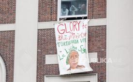 Mahasiswa menggantungkan tanda baru di jendela Hamilton Hall mengikuti mahasiswa pro-Palestina. 