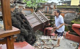 Warga membersihkan puing-puing bangunan peribadatan yang rusak akibat angin puting beliung di kawasan Sidakarya, Denpasar, Bali, Rabu (21/1/2026). Bencana angin puting beliung yang terjadi pada Rabu (21/1) dini hari tersebut merusak sekitar 35 rumah dan sejumlah bangunan peribadatan milik warga di kawasan tersebut. 