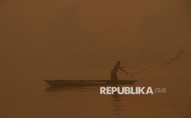 Nelayan mencari ikan di Sungai Kahayan yang diselimuti asap kebakaran hutan dan lahan (karhutla) di Palangka Raya, Kalimantan Tengah, Sabtu (24/10/2026).