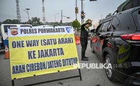 Anggota polisi mengarahkan mobil yang hendak masuk ke tol arah Jawa ke jalur arteri saat sterilisasi jelang penerapan rekayasa lalu lintas satu arah atau one way di ruas Gerbang Tol Cikampek, Karawang, Jawa Barat, Jumat (27/3/2026). Korps Lalu Lintas (Korlantas) Polri mulai menerapkan rekayasa satu arah di Tol Trans Jawa arah Jakarta mulai dari KM 263 ruas Tol Pejagan-Pemalang hingga KM 70 ruas Tol Jakarta-Cikampek dan akan memberlakukan one way nasional apabila sekitar 4.000 kendaraan melintas di KM 414 Gerbang Tol Kalikangkung.  
