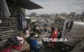 Keluarga Atallah duduk di luar rumah mereka yang rusak akibat pemboman Israel, di Kota Gaza, Jumat (14/11/2025). Tanpa infrastruktur yang memadai, pemandangan di kamp-kamp pengungsian menunjukkan warga menumpuk batu dan pasir untuk mengangkat alas tidur agar tidak terendam, sementara lainnya mencari sudut apa pun yang masih kering setelah hujan turun. 