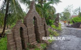 Sejumlah anak-anak bermain di area candi paving di Desa Sembulungan, Cluring, Banyuwangi, Jawa Timur, Ahad (8/2/2026). Sebanyak 13 bangunan menyerupai candi yang terbuat dari bahan paving material proyek pembangunan jalan yang tak kunjung dikerjakan itu dibangun warga menjadi karya seni dan bentuk protes karena menyebabkan penyempitan dan mengganggu pengguna jalan. 