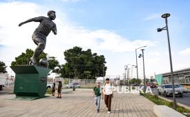 Warga melintas di dekat patung mantan legenda sepak bola Brasil, Edson Arantes do Nascimento atau Pele, di Guadalajara, Meksiko, Kamis (21/5/2026). Patung Pele setinggi 9,5 meter yang terbuat dari perunggu berdiri megah di depan Stadion Jalisco. Patung tersebut diresmikan untuk menyambut perhelatan Piala Dunia 2026, yang akan dimainkan di stadion-stadion di Meksiko, Amerika Serikat, dan Kanada. 