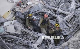 Tentara Israel mencari korban selamat di tengah reruntuhan bangunan tempat tinggal yang hancur akibat serangan rudal Iran di kota Bat Yam, Israel tengah, Ahad (15/6/2025).