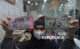 Karyawan menunjukkan uang pecahan dolar Amerika Serikat (AS) dan rupiah di gerai penukaran mata uang asing di Jakarta. (ilustrasi)