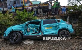 Warga mengamati taksi listrik Green SM yang rusak  akibat tertabrak KRL Commuter di Bekasi Timur, Jawa Barat, Selasa (28/4/2026). Kementerian Perhubungan akan melakukan evaluasi menyeluruh menyusul kecelakaan KRL dengan KA Argo Bromo di Stasiun Bekasi Timur. Evaluasi juga mencakup keterlibatan taksi asal Vietnam, Green SM, yang mogok perlintasan sebidang dan diduga menjadi pemicu awal insiden.