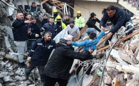  Yigit Cakmak berusia delapan tahun (depan 2-R, warna biru) dibawa ke tempat aman dari puing-puing bangunan yang runtuh, sekitar 52 jam setelah gempa besar, di Hatay, Turki, Rabu (8/2/2023). Lebih dari 7.000 orang telah meninggal dan ribuan lainnya terluka setelah dua gempa besar melanda Turki selatan dan Suriah utara pada Senin (6/2/2023).