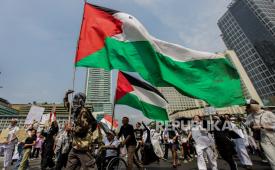 Peserta aksi mengibarkan bendera Palestina. Menlu Spanyol Albares kritik sikap memalukan Israel 