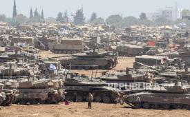 Tentara Israel dengan kendaraan militer berkumpul di posisi yang dirahasiakan di dekat pagar perbatasan dengan Jalur Gaza, di Israel selatan, 9 Mei 2024.