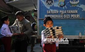 Siswa membawa makan bergizi gratis di Sekolah Madrasah Ibtidaiyah Negeri Medan, Sumatera Utara, Rabu (14/1/2026). Kementerian Keuangan melaporkan program Makan Bergizi Gratis (MBG) telah menyerap anggaran sebesar Rp51,5 triliun per 31 Desember 2025 atau setara 72,5 persen dari pagu Rp71 triliun pada APBN 2025. 