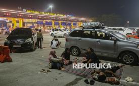Warga menyantap hidangan saat waktu sahur di Gerbang Tol Cikampek Utama, Karawang, Jawa Barat, Kamis (18/3/2026). Sejumlah pemudik memilih menghabiskan waktu sahur dan beristirahat di bahu jalan Gerbang Tol Cikampek Utama lantaran terjadi penumpukan pemudik di rest area.