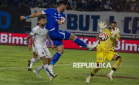 Pesepak bola Persib Bandung Julio Cesar De Freitas Filho (tengah) menendang bola dan berupaya dihalau penjaga gawang Arema FC Lucas Henrique Frigeri pada pertandingan lanjutan BRI Super League di Stadion Gelora Bandung Lautan Api (GBLA), Bandung, Jawa Barat, Jumat (24/4/2026). Pertandingan berakhir imbang dengan skor 0-0. 