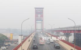 Foto udara petugas dari Damkar Satuan Polisi Pamong Praja (Sat Pol PP) Provinsi Sumatera Selatan menyemprotkan air atau water mist saat melintas di Jembatan Ampera Palembang, Sumatera Selatan, Rabu (14/10/2026). Penyemprotan air sebanyak 10.000 liter per hari tersebut bertujuan untuk meminimalkan debu dan residu kebakaran hutan dan lahan (Karhutla) di sejumlah ruas jalan Kota Palembang yang dilaksanakan sejak Ahad (11/10). 